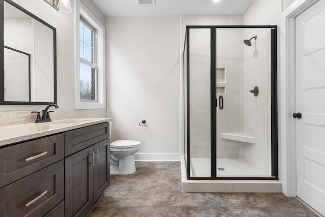 full bathroom featuring toilet, visible vents, vanity, baseboards, and a shower stall