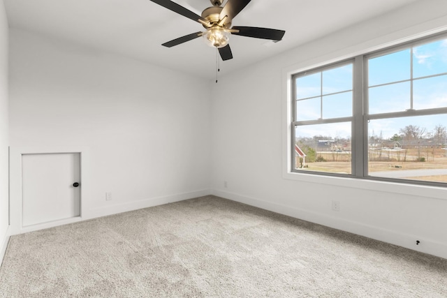 empty room with ceiling fan, carpet floors, and baseboards