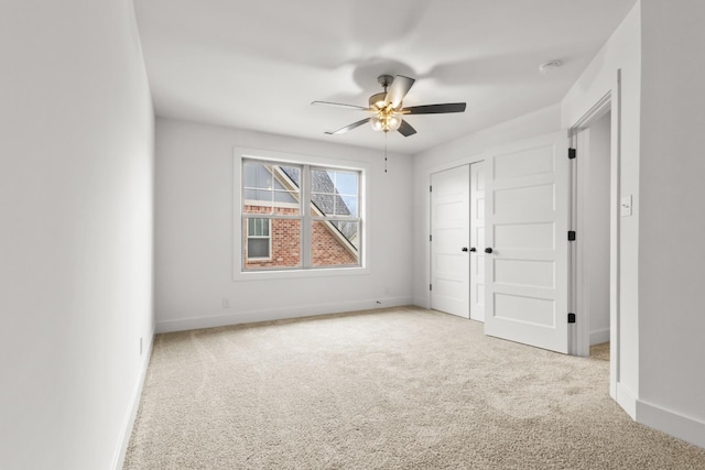 unfurnished bedroom with a ceiling fan, baseboards, a closet, and light colored carpet