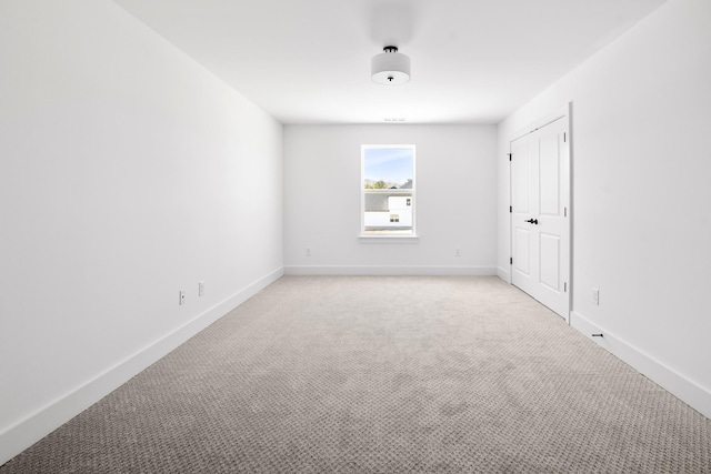 unfurnished bedroom with baseboards, a closet, and light colored carpet