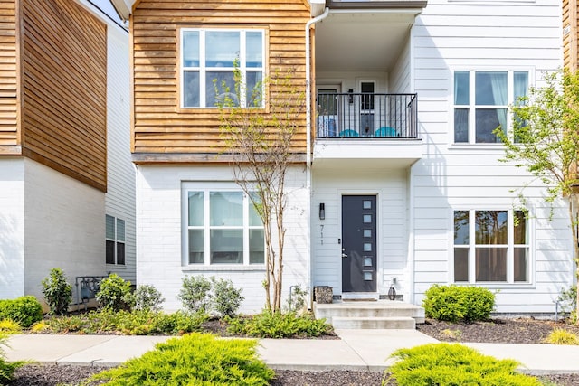 view of exterior entry featuring brick siding