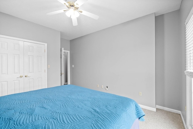 carpeted bedroom featuring a closet, ceiling fan, and baseboards