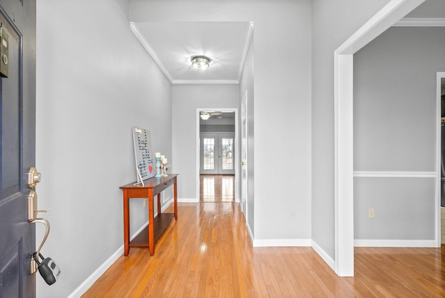 foyer entrance with ornamental molding, french doors, baseboards, and wood finished floors