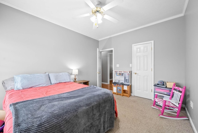 carpeted bedroom with ceiling fan, baseboards, and crown molding