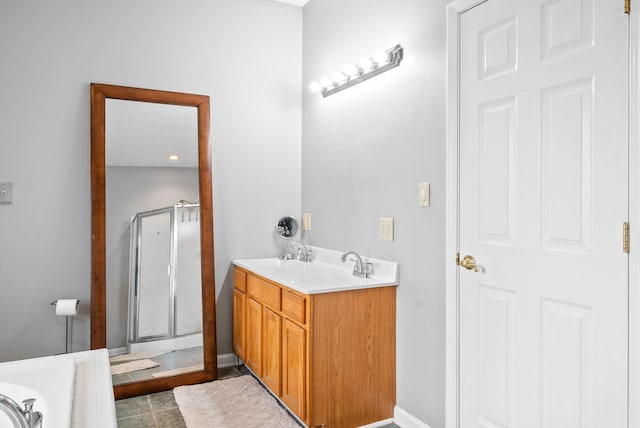 bathroom with a relaxing tiled tub, a sink, baseboards, double vanity, and a stall shower