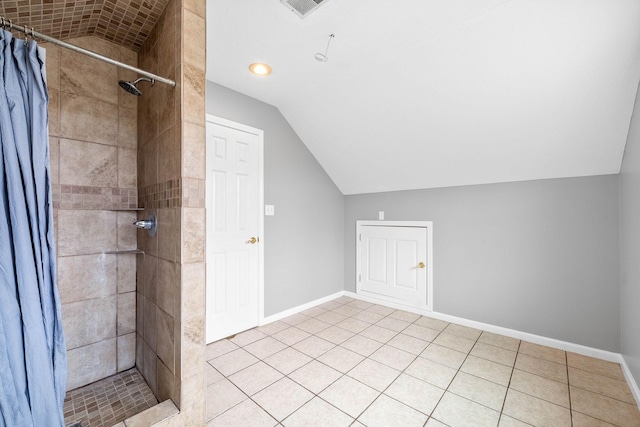 bathroom with a stall shower, visible vents, lofted ceiling, and baseboards