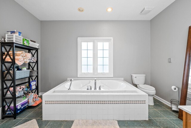 bathroom featuring baseboards, visible vents, toilet, a bath, and recessed lighting