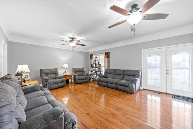 living room featuring light wood-type flooring, ornamental molding, a ceiling fan, and french doors