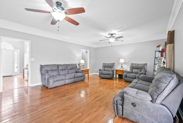 living room featuring baseboards, ornamental molding, and wood finished floors