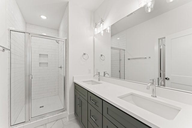 bathroom featuring a stall shower, marble finish floor, a sink, and double vanity