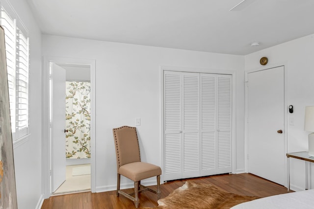 bedroom with a closet, multiple windows, and wood finished floors