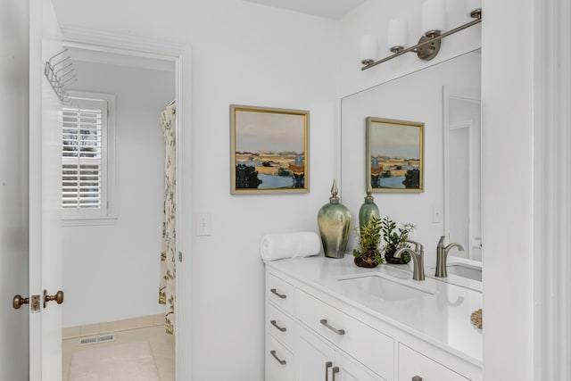 bathroom featuring curtained shower, vanity, and visible vents