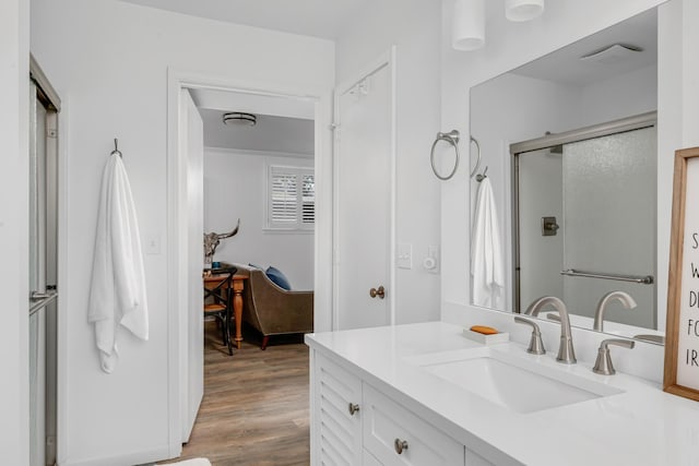 bathroom with visible vents, vanity, a shower stall, and wood finished floors