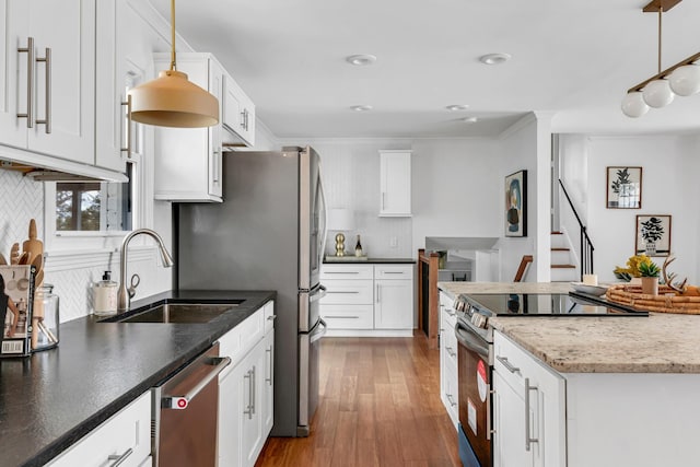 kitchen with stainless steel appliances, white cabinets, hanging light fixtures, and a sink