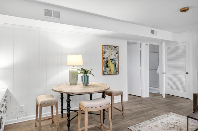 dining space with baseboards, visible vents, and wood finished floors