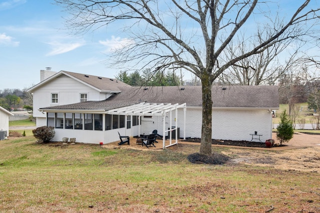 back of property with a lawn, a sunroom, a chimney, roof with shingles, and a pergola