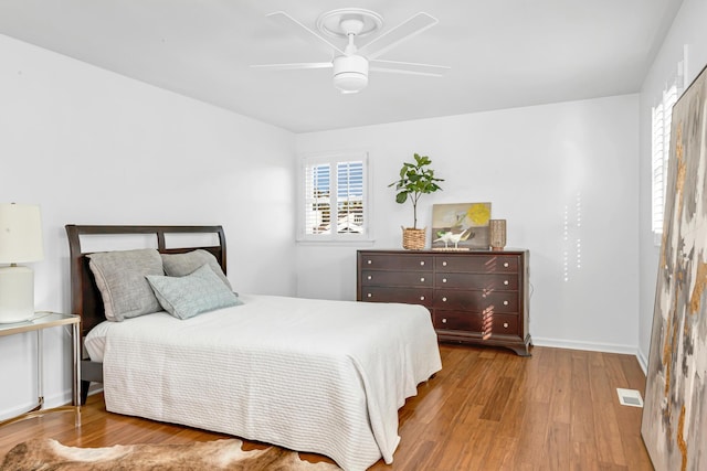 bedroom featuring light wood-style flooring, visible vents, ceiling fan, and baseboards