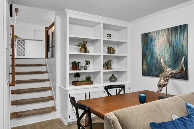 dining room featuring stairs, built in shelves, dark wood-type flooring, and crown molding