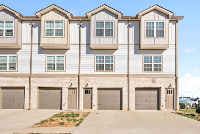 multi unit property featuring a garage, board and batten siding, and driveway