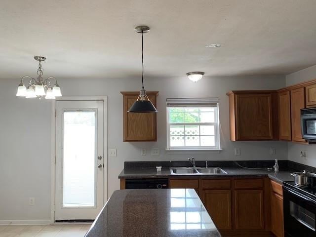 kitchen featuring pendant lighting, dark countertops, black electric range oven, brown cabinetry, and a sink