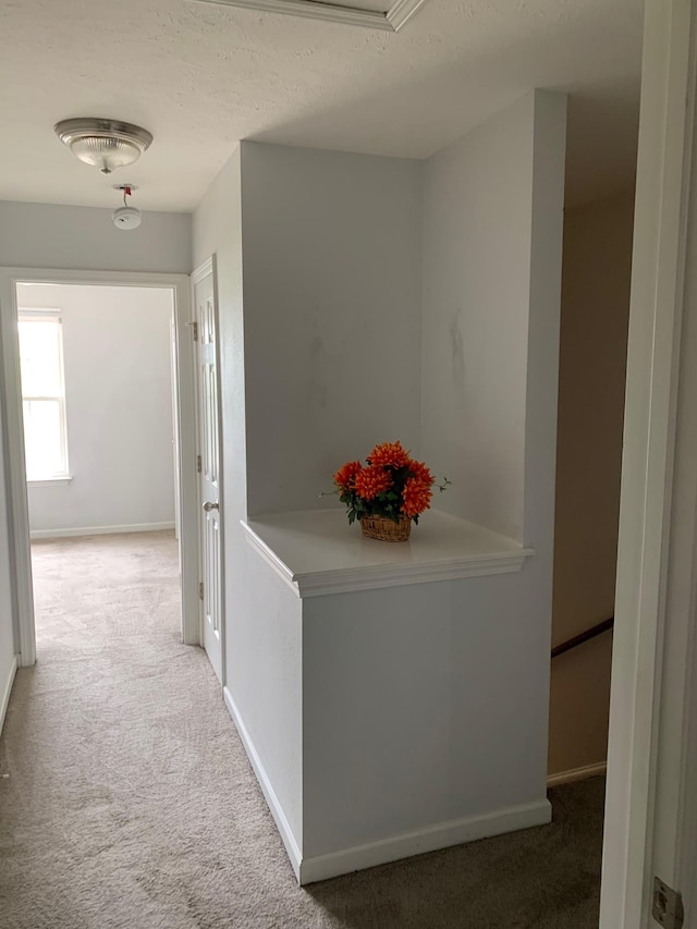 corridor featuring carpet flooring and baseboards