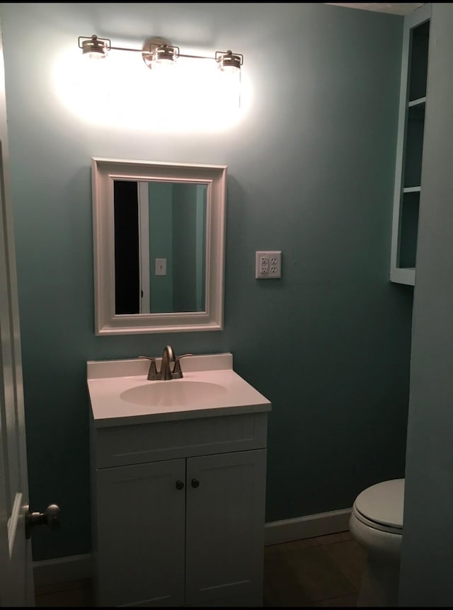 bathroom featuring toilet, baseboards, vanity, and tile patterned floors