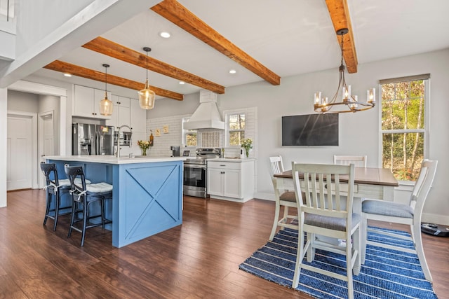 kitchen with stainless steel appliances, light countertops, hanging light fixtures, white cabinets, and premium range hood