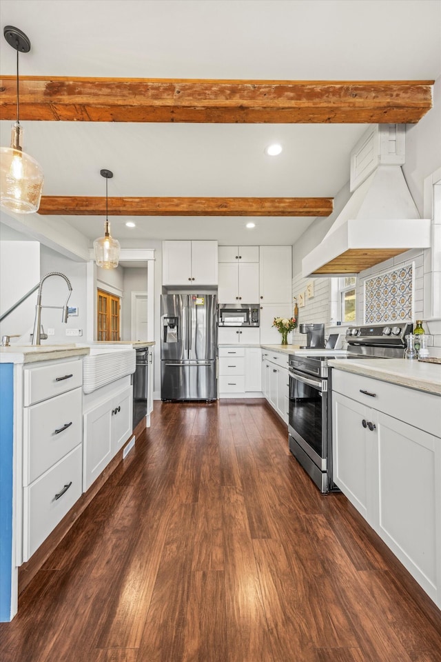 kitchen with appliances with stainless steel finishes, decorative light fixtures, custom exhaust hood, light countertops, and white cabinetry