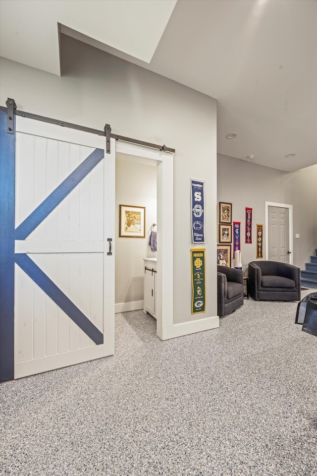 interior space with stairs, speckled floor, a barn door, and baseboards