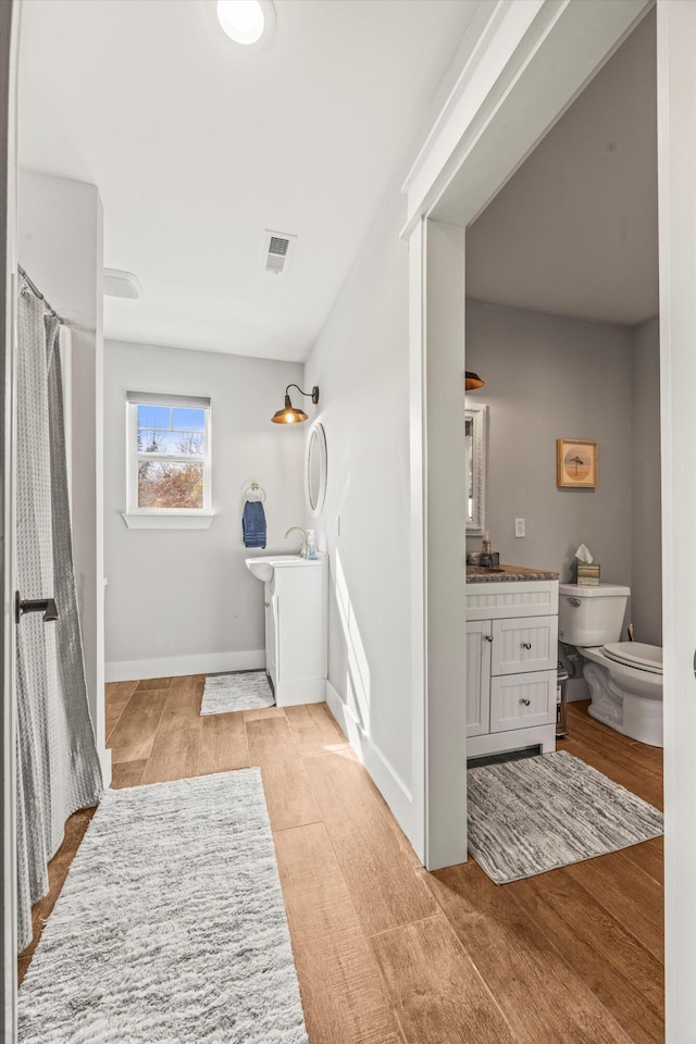 bathroom with baseboards, visible vents, vanity, and toilet