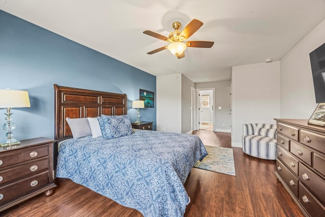 bedroom featuring dark wood-type flooring, a ceiling fan, and baseboards