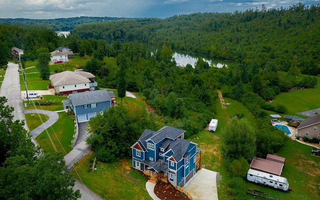 drone / aerial view featuring a residential view, a water view, and a wooded view