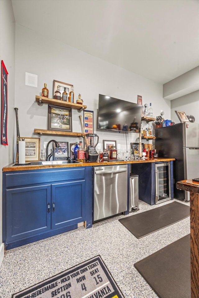 bar featuring wine cooler, wet bar, stainless steel appliances, and a sink