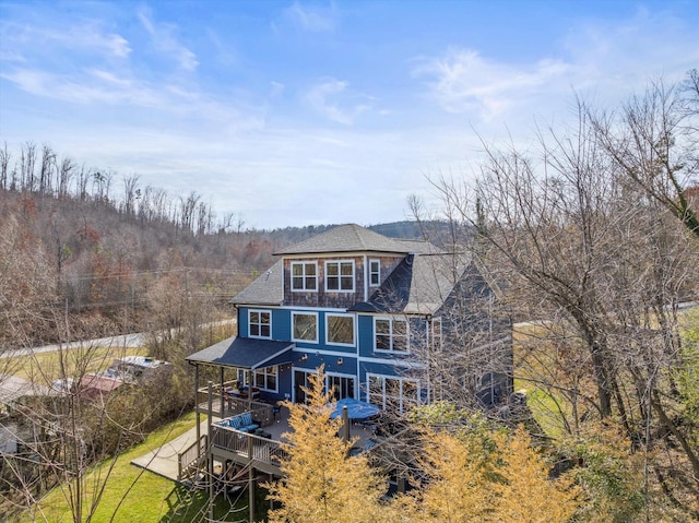 rear view of house featuring a deck and a yard