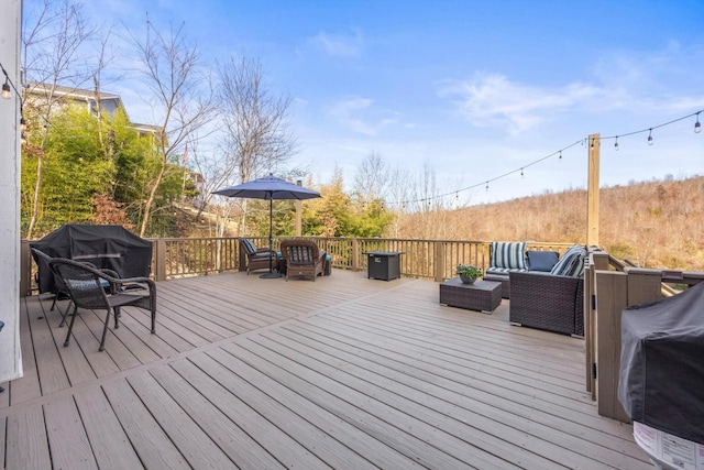 wooden deck with grilling area and an outdoor living space