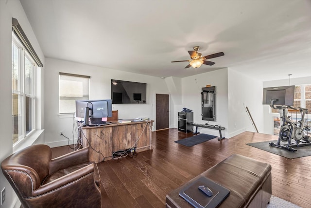 living room featuring wood finished floors, a ceiling fan, and baseboards