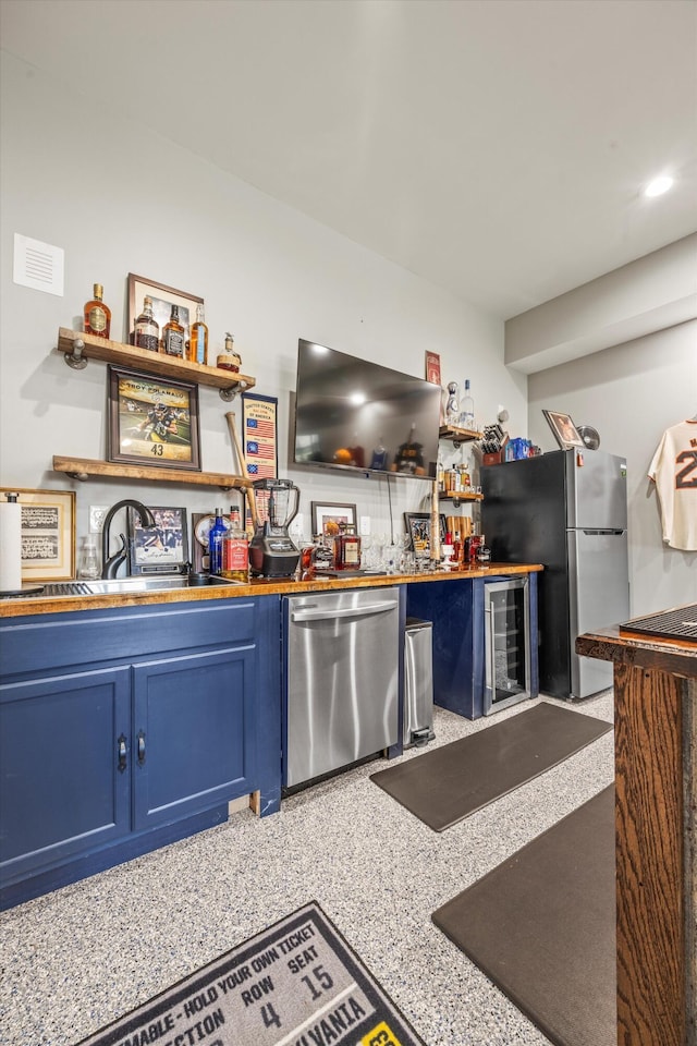 bar featuring wine cooler, a sink, visible vents, appliances with stainless steel finishes, and indoor wet bar