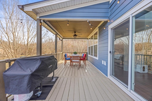 wooden terrace with a grill, a ceiling fan, and outdoor dining space