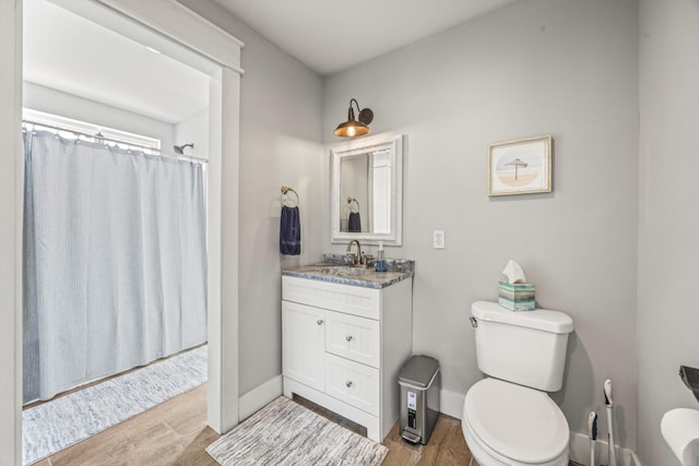 full bathroom featuring baseboards, toilet, a shower with curtain, wood finished floors, and vanity