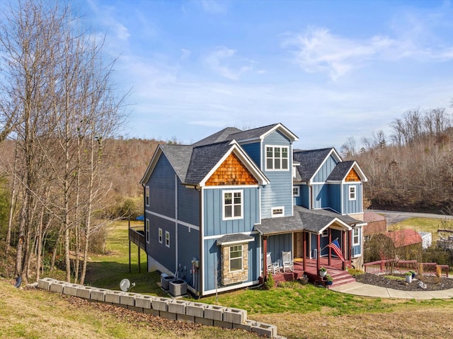 view of front of property with board and batten siding, a front yard, and cooling unit