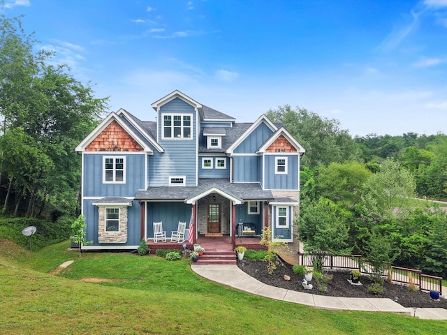 craftsman inspired home featuring fence, board and batten siding, a porch, and a front lawn