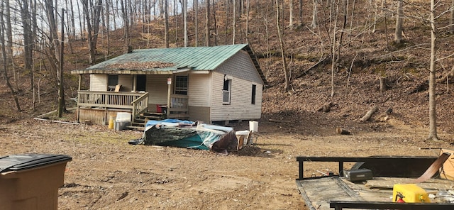 exterior space featuring metal roof and a forest view