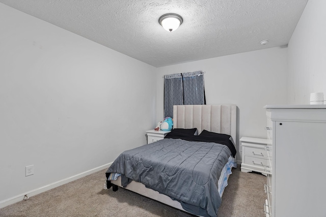 bedroom featuring dark carpet, a textured ceiling, and baseboards