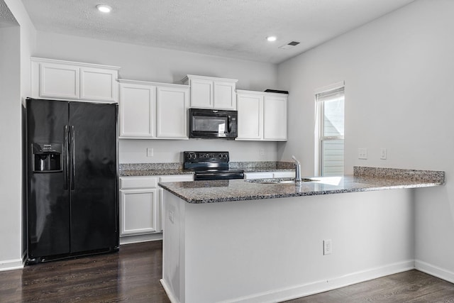 kitchen featuring dark wood-style floors, visible vents, white cabinets, a peninsula, and black appliances