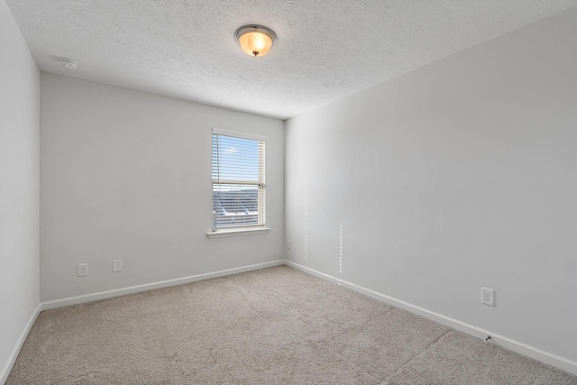 unfurnished room with carpet, a textured ceiling, and baseboards