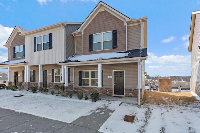 view of front of home with a porch and stone siding