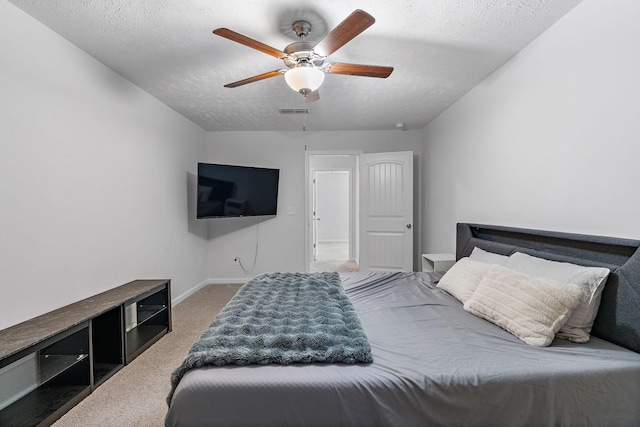 carpeted bedroom with a ceiling fan, visible vents, a textured ceiling, and baseboards