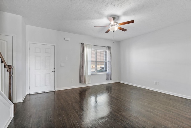 unfurnished room with a textured ceiling, dark wood-style flooring, a ceiling fan, baseboards, and stairs