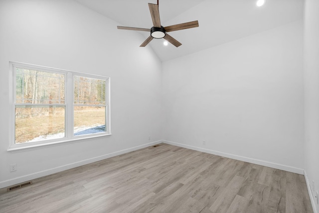 unfurnished room featuring baseboards, visible vents, a ceiling fan, light wood-style flooring, and high vaulted ceiling