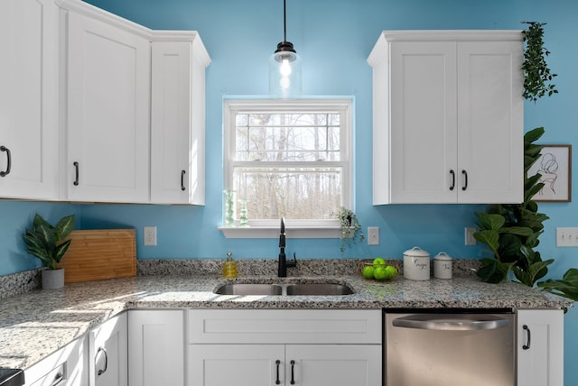 kitchen featuring pendant lighting, white cabinetry, a sink, light stone countertops, and dishwasher